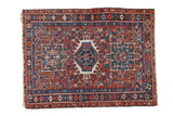 Vintage Persian Karaja rug with a triple center medallion over a geometric brick red and navy field.