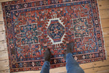 A viewer's perspective of the vintage Karaja rug's triple medallion and polychromatic geometric field.