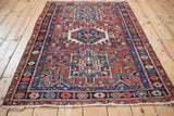 Full length angled view of a vintage Persian Karaja rug's geometric field and borders.