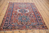 A vintage Karaja rug's geometric pattern and triple medallion, viewed from a high corner perspective.