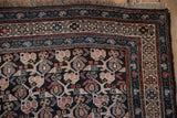 Vintage Kurdish rug corner detail showing geometric border and boteh lattice with blush, blues, and dark brown tones, consistent wear.