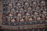 Corner detail of vintage Kurdish rug with blush floral boteh lattice and geometric borders.