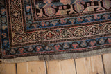 Vintage Kurdish rug corner: geometric motifs in dark brown, blue, blush, and visible foundation.