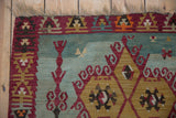 Vintage Turkish Kilim rug detail: black cherry red geometric border and seafoam abrash.