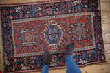 Vintage Karaja rug with a triple geometric medallion in navy and sky blue on a brick red field.