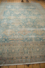 Distressed floral border, fringed end, and worn blue, ivory palmette field of a vintage Agra rug.