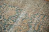 Distressed texture of vintage Agra carpet with worn pile, visible foundation, dusty blue, and tan tones.