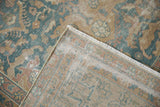Worn pile of vintage Agra carpet revealing foundation, side selvage, and light ivory fringe.
