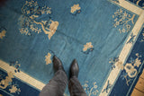 Antique Peking carpet's central sky blue field with a pictorial tree, hut, and blossomed floral sprays.