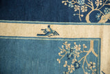 Antique Peking carpet detail with bird motif and floral designs in cobalt and ivory.