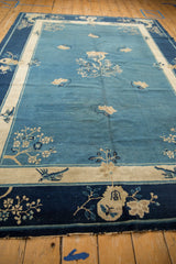 Antique Chinese Peking carpet corner with dark cobalt border and intricate beige floral motifs.