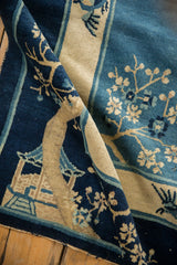 Antique Peking rug's textured pile with hut and floral motifs in cobalt and ivory.