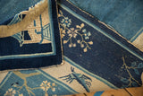 Antique Peking carpet's folded edge, showing hand-knotted texture, intact selvage, and blue design.