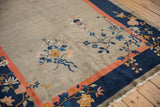 Chinese Art Deco rug corner: cobalt blue, coral border, delicate floral vines, and worn fringe.