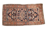 Antique Kurdish rug with a quatrefoil medallion and palmettes in rose and blue on a dark navy field.
