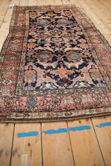 Angled view of the antique Kurdish rug, revealing its natural contour and complex arabesque design.