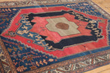 Cherry red and navy blue field with bold zig-zag lines and stylized primitive motifs of an antique Malayer rug.