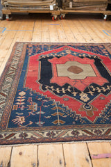 Antique Malayer rug with fine weave showing primitive geometric motifs in navy blue and cherry red.
