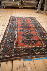 Low perspective view of an antique Kurdish rug's repeating diamond medallion column.