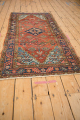 Heriz rug's stepped spandrels and diamond floral patterns with vivid blue abrashes.