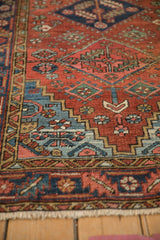 Vintage Heriz rug runner detail: stepped blue spandrel, floral motifs, and fringe.