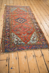 Stepped powder blue corner spandrel and navy border on a gem-toned vintage Heriz rug.