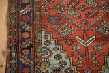 Vintage Heriz rug with wear on stepped light blue spandrel, brick red field, dark blue border.