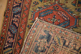 A corner detail of an antique Heriz rug showing the hand-knotted back and low wool pile.
