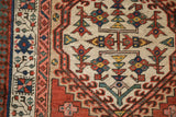 Interconnected germinating floral motif with jade green and navy vine border on an antique Serab rug.