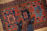 Vintage Karaja rug's geometric medallion with brick red, navy, sky blue, and blush floral motifs.