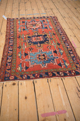 Angled view of vintage Karaja rug, brick red field, geometric medallions, meandering vine borders.