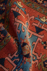 Rich hand-knotted pile and vibrant geometric floral patterns on a folded vintage Karaja rug.