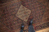 Antique Farahan Sarouk rug's ivory medallion corner, navy field with henna plant motif, and Herati border.