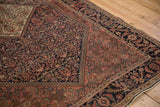 Antique Farahan Sarouk rug's navy henna plant design, cochineal spandrel, Herati border.