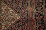 Antique Farahan Sarouk rug corner: ivory spandrel, navy field, inverted henna plant design.