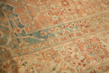 Close-up of henna plant motifs within the trellis pattern of a distressed Malayer carpet.