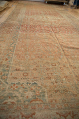 Long view down the field of a distressed Malayer carpet showing terracotta and blue abrash.