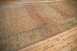 Angled view down the length of the distressed Persian Malayer carpet showing rich terracotta abrashes.