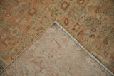 Corner of a vintage Malayer rug folded to show its hand-knotted foundation and wear.