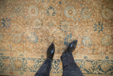 Overhead view of the distressed low pile and floral pattern of an antique Khoy carpet.