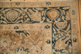 Corner detail of a distressed Khoy carpet's floral border in dusty blue and bronze, with even wear to knot heads.