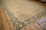Low angle view across the time-softened worn pile of an antique gold wash Persian Khoy carpet.