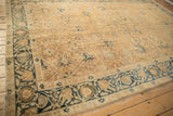 Angled view of the antique Khoy carpet's low pile, showing the dusty blue floral border.