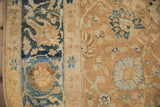 Close-up of the antique Khoy carpet's worn knot heads and floral vinery in blue and coffee brown.