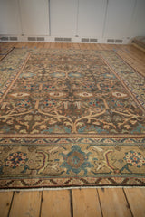 Angled perspective showing the distressed texture and floral lattice pattern of a vintage Mahal carpet.
