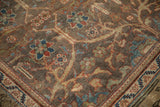Angled close-up of the distressed texture and floral lattice design on a vintage Mahal carpet.