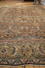 Low angle view on the distressed texture and floral lattice design of a vintage Mahal carpet.