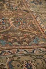 Close-up angle showing the distressed, low-pile texture of the vintage Mahal carpet's floral pattern.