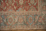 Close-up of the vintage Mahal carpet's worn texture, showing pale raspberry and slate blue floral borders.