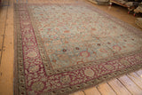 Distressed Persian Yezd carpet corner, showing dusty blue field, Safavid palmettes, and burgundy border.